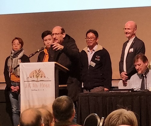 Pastor Mark Thomas blesses Pastor Charlie Mach and representatives of Antioch Church as Synod accepts their membership application.