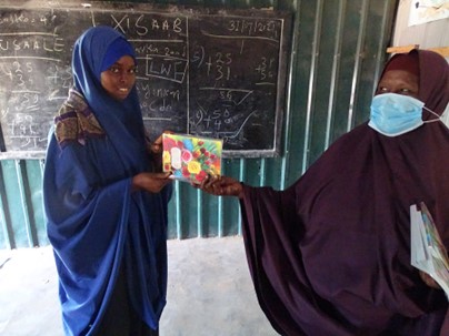 Aamiina receiving her school resources. Photo Credit: LWF Somalia.
