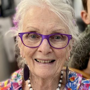 Image of Margraret Curnow OAM wearing purple glasses and a brightly coloured shirt