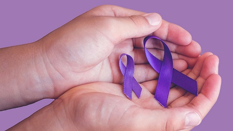 Hands holding purple domestic violence ribbons
